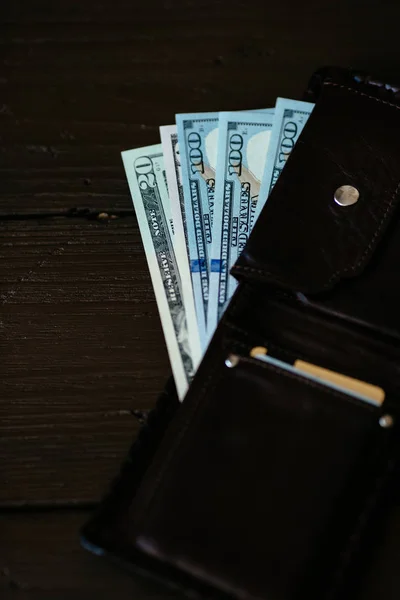 Wallet with dollars cash. Open wallet with dollars banknotes and credit cards on wooden background