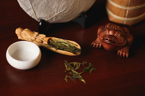 Закрывай. Китайский зеленый чай Longjing раскинулся на бамбуковой ложке . — стоковое фото