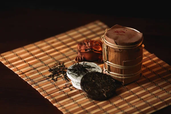 Teh puer Cina dengan patung Buddha di latar belakang gelap. Teh tradisional Cina . — Stok Foto