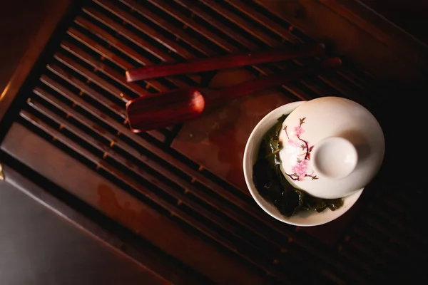 Cérémonie du thé chinois. Gaiwan blanc de porcelaine sur chaban de bureau de thé. Vue du dessus . — Photo