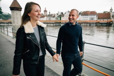 Mutlu çift aşık elini tutarak ve gülümseyen waterfront adlı yürüyüş