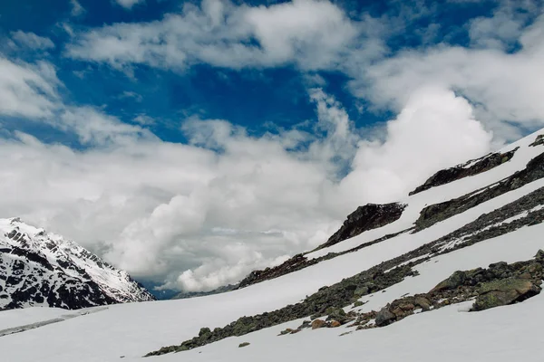 Veduta delle rocce innevate in estate nelle Alpi svizzere — Foto Stock