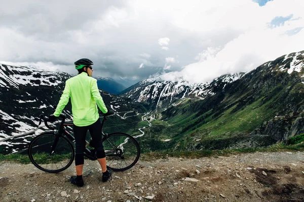 Cyclist standing with road bikes on background of beautiful Alpine mountains landscape