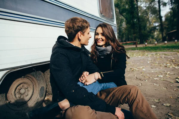 Hermosa pareja enamorada se sienta en el suelo y se mira el uno al otro en un día soleado . — Foto de Stock