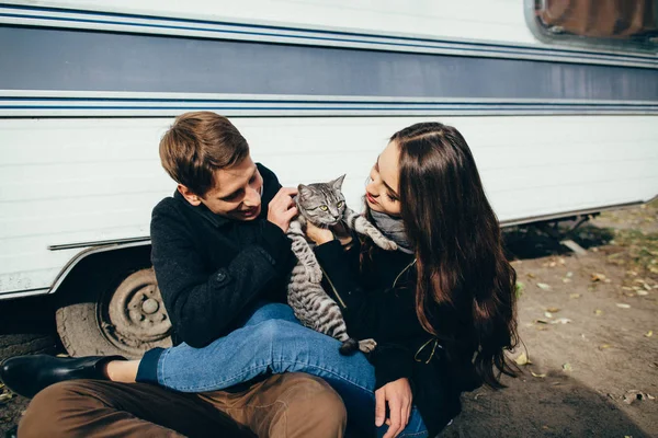 Hermosa pareja enamorada jugando con el gato. Historia de amor — Foto de Stock