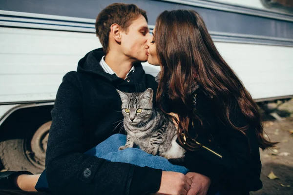 Pareja en amor besos mientras gris gato sentado en regazo — Foto de Stock