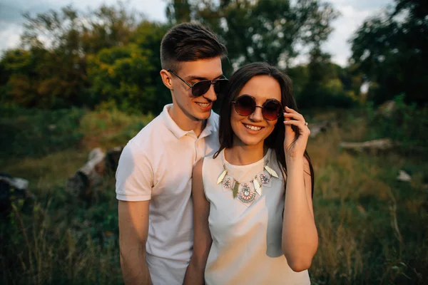 Portret van gelukkige mooie paar in zonnebril bij zonsondergang — Stockfoto