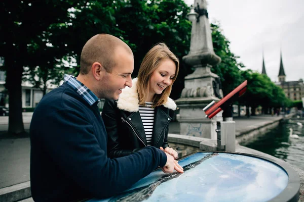 Happy young couple of Travelers looking at map and points a finger at location on the viewing platform