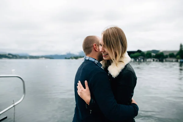 Couple heureux d'amoureux câlins et souriants près du lac — Photo