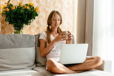Kadın evde kanepe üstünde laptop üzerinde TV dizi izlemek