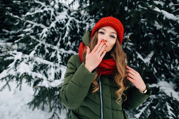 Красивая женщина посылает поцелуй в камеру в зимний снежный лес — стоковое фото