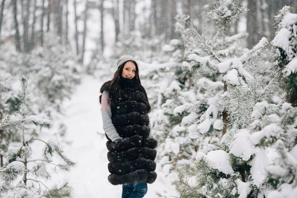 Gilet femme en fourrure d'hiver marchant dans la forêt d'hiver — Photo