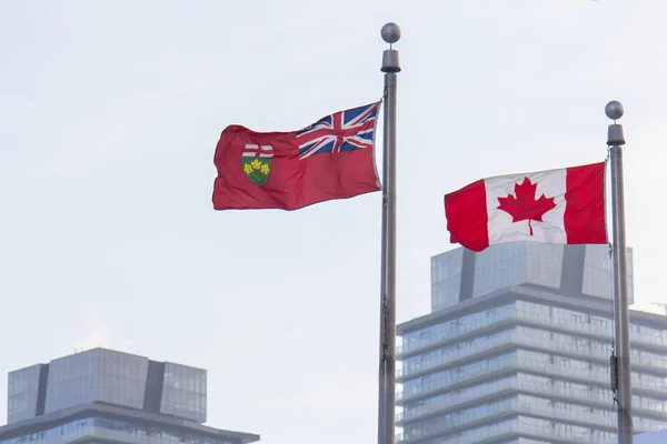 Kanada und Ontarios Flaggen vor Wolkenkratzern in Toronto — Stockfoto