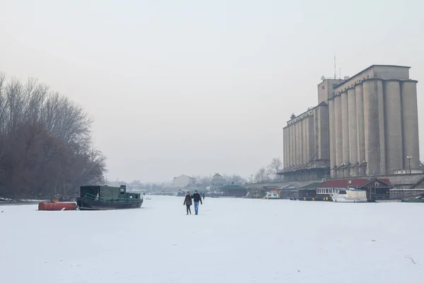 Pancevo, Serbia - 22 de enero de 2017: Personas que caminan sobre el río congelado Tamis - Timis (un afluente del Danubio) debido a un clima excepcionalmente frío en los Balcanes que dura más de 10 días — Foto de Stock