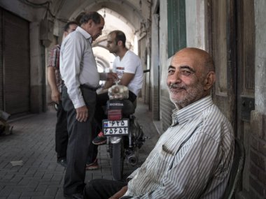 : Kashan, Iran - 13 Ağustos 2016: bir kapanış anlaşma sonra ile dost İran halkının Kaşan ın Bazaarı planda gülümseyen eski İran yumurta satıcı