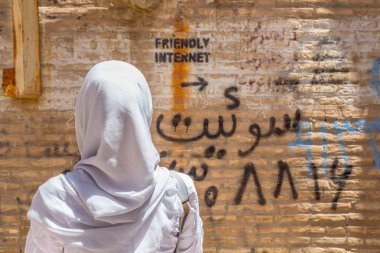 Yazd, Iran - 18 Ağustos 2016: sansürsüz Internet spot gösteren duvar üzerinde bir yazıt bakarak peçeli kadın