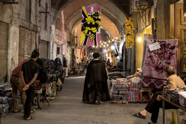 Isfahan, Iran - August 20, 2016: Imam passing under a Batman logo in Isfahan bazaar — Stock Photo, Image
