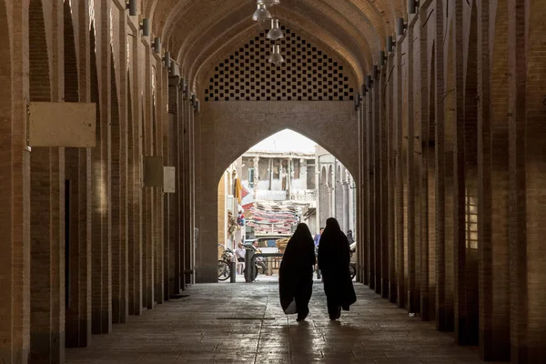 Isfahán, Irán - 20 de agosto de 2016: Mujeres con el velo islámico caminando por una calle del bazar cubierto de Isfahán — Foto de Stock