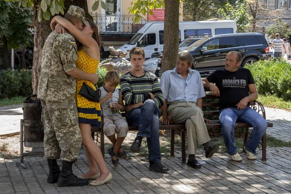 Κίεβο, Ουκρανία - 9 Αυγούστου 2015: Ουκρανικά στρατιώτης σε άδεια από την ανατολική Ουκρανία σύγκρουση φιλί φίλη δίπλα από τους συγγενείς του — Φωτογραφία Αρχείου