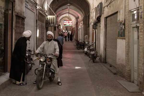 YAZD, IRÁN - 18 de agosto de 2016: Imames iraníes con ropa tradicional discutiendo mientras estaban en una motocicleta en una calle cubierta de Yazd Bazaar — Foto de Stock