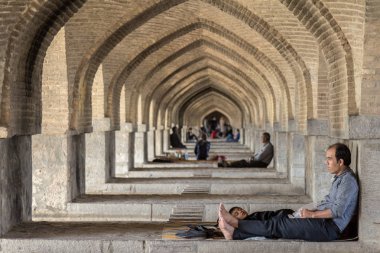 Isfahan, Iran - 20 Ağustos 2016: İran halkının Khaju Köprüsü, Isfahan, kemerlerin altında yaz daha sıcak saatlik dinlenme