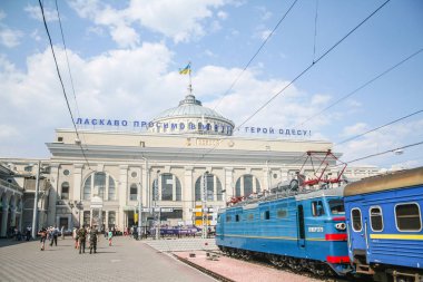 Odessa, Ukrayna - 6 Ağustos 2014: Odessa tren istasyonunun ana binası ve Ukrayna demiryollarından (ukrzaliznytsia) geçen yolcular ve platformlar üzerinde bir yolcu treni