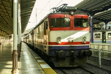 Güneşli bir günbatımında Sirkeci Gar tren istasyonuna varan Türk demiryolu yolcu ekspresi. Sirkeci, İstanbul, Türkiye 'nin Avrupa tarafındaki ana terminallerinden biridir.