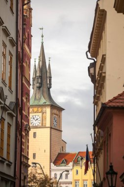 Prag, Çek Cumhuriyeti 'nin tarihi merkezi olan Stare Mesto' nun tipik dar caddesi, çan kulesi ve bir ortaçağ barok kilisesinin saat kulesi üzerine odaklanmıştır.
