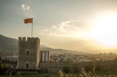 Makedonya 'nın başkenti Kuzey kentinde, Üsküp Kalesi' nin Üsküp Kulesi 'nin manzarası ve dalgalanan bir Makedon bayrağıyla birlikte görülüyor.