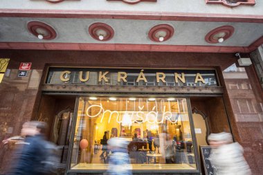 Prag, Çek Cumhuriyeti - 31 Ekim 2019: Prag şehir merkezinden insanların önünden geçtiği tipik bir Cukrarna Mysal pastanesi. Burası kek ve tatlı satan tipik bir kahve dükkânı.