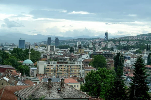 Bosna-Hersek 'in Saraybosna şehir merkezinin panoraması yukarıdan görülüyor. Yağmurlu bir öğleden sonra, camiler ve gökdelenler gibi eski kasabaların büyük simgeleri görülebilir.