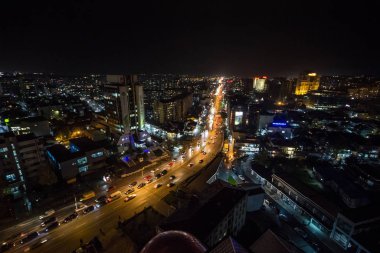 PRISHTINA, KOSOVO - NOVEMBER 11, 2016: Prishtina 'da Bill Clinton Bulvarı ve George W Bush Bulvarı' nın gece manzarası ve yanından geçen arabalar. Priştine Kosova 'nın başkenti