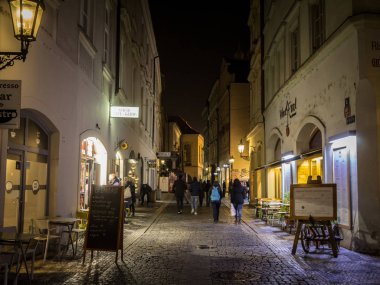 Prag, Çek Cumhuriyeti - 31 Ekim 2019: Geceleyin buradan geçen turistlerle birlikte Zelezna Caddesi. Çakıl taşlarıyla döşenen cadde, Prag şehir merkezi Stare Mesto 'nun restoran ve barlarıyla simgesel bir simgesidir.