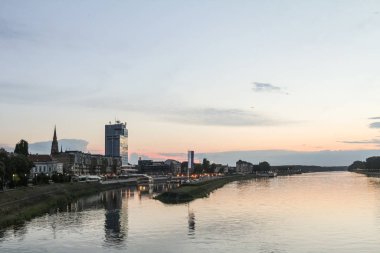 Drava Nehri 'nden Osijek' in gökdelenleri ve şehrin katedrali ile panorama ve silueti. Osijek, Hırvatistan 'ın kuzeyindeki Slavonya bölgesinin büyük bir şehridir.