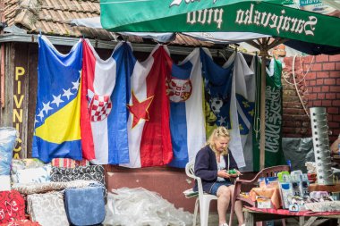 BRCKO, BOSNIA - 19 Haziran 2016: Bosna-Hersek, Sırbistan, Hırvatistan ve Yugoslavya 'nın bayrakları, Dayton anlaşmaları nedeniyle özel statüsü nedeniyle Brcko ilçesindeki bir pazarda sergileniyor