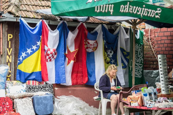 BRCKO, BOSNIA - 19 Haziran 2016: Bosna-Hersek, Sırbistan, Hırvatistan ve Yugoslavya 'nın bayrakları, Dayton anlaşmaları nedeniyle özel statüsü nedeniyle Brcko ilçesindeki bir pazarda sergileniyor