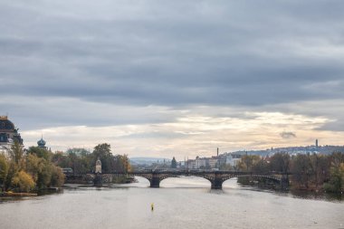 Çek Cumhuriyeti 'nin Prag kenti, Vltava nehrinden, Moldau olarak da adlandırılan Panorama' da, sonbaharda bulutlu bir günbatımında şehrin simgelerinden biri olan Most Legii ya da Legion Most üzerinde duruluyor.