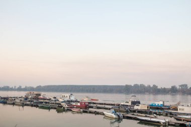 Zemun liman ve limanına demirlemiş botlar, Sırbistan 'ın Belgrad kentindeki Zemunski marinasının tipik dubası, Tuna Nehri üzerindeki ana navigasyon merkezlerinden biri.