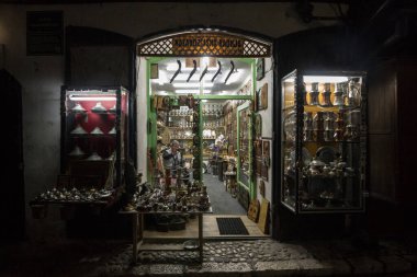 SARAJEVO, BOSNIA - 15 Nisan 2017: Saraybosna 'nın Bascarsija ilçesindeki hediyelik eşya dükkanı, tipik metal el sanatları üretiliyor. Bascarsija, doğu mimarisiyle Saraybosna 'nın simgesi oldu