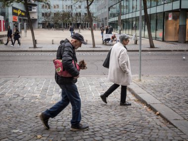 PRAG, CZECHIA - 3 Kasım 2019: yaşlı bir adam, Prag sokaklarında yürüyen yaşlı bir adam, bir Yorkshire cinsi köpeğini tutuyor..
