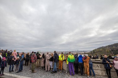 PRAG, CZECHIA - 2 Kasım 2019: Prag, Çek Cumhuriyeti 'nin havadan çekilmiş bir manzarasını izleyen turist kalabalığı, sonbahar bulutlu bir öğleden sonra kalenin tepesinden görüldü.