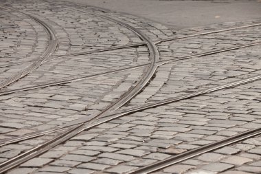 Tramvay raylarının üzerinde eski ve modası geçmiş bir caddenin kaldırımında tramvay trenleriyle toplu taşımanın sağlandığı yerde.