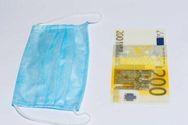 Koruyucu tıbbi maske ve beyaz arka planda Avro banknotları. Pahalı tıp konsepti.