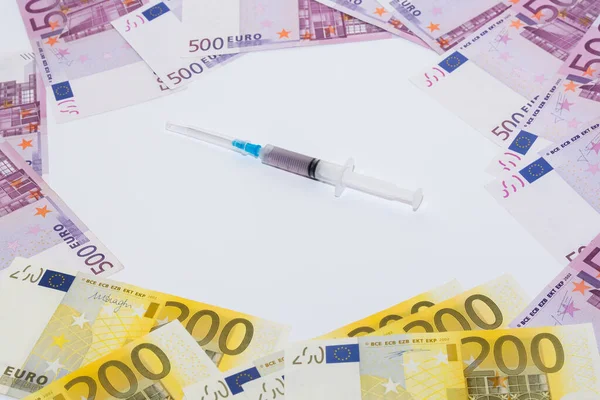 Syringe vaccine and euro bills. Expensive medicine concept.