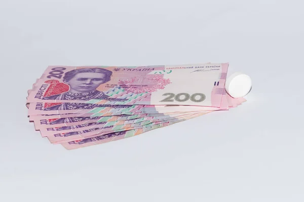 Tabletler ve beyaz arka planda Ukrayna Hryvnia 'sı. Pahalı tıp konsepti.