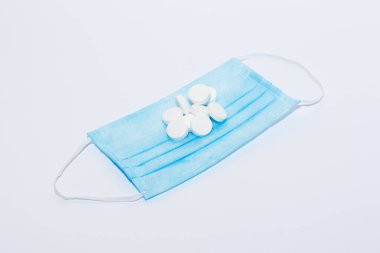 Tabletler ve beyaz arka planda koruyucu tıbbi maske. Pahalı tıp konsepti.