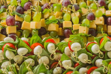 Aperatif kanepe peyniri beyaz ve kırmızı üzümlü ve domatesli bambu şiş.