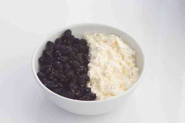 Morus Nigra, siyah renkli ve süzme peynirli Mulberry 'i çağırdı. Beyaz tabakta. Dut Gıda Arkaplanı.