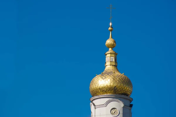 Isolated Dome of the Christian church with clock. Blue background.