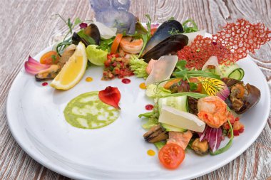 Beyaz tabakta deniz ürünleri salatası.